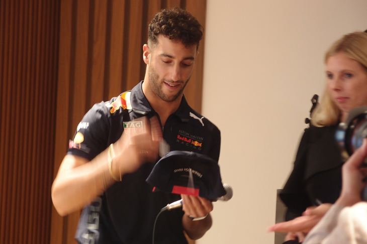 会場では、ファンにグッズのプレゼントも。写真はレーシングチームのオリジナルキャップにサインしているところ。