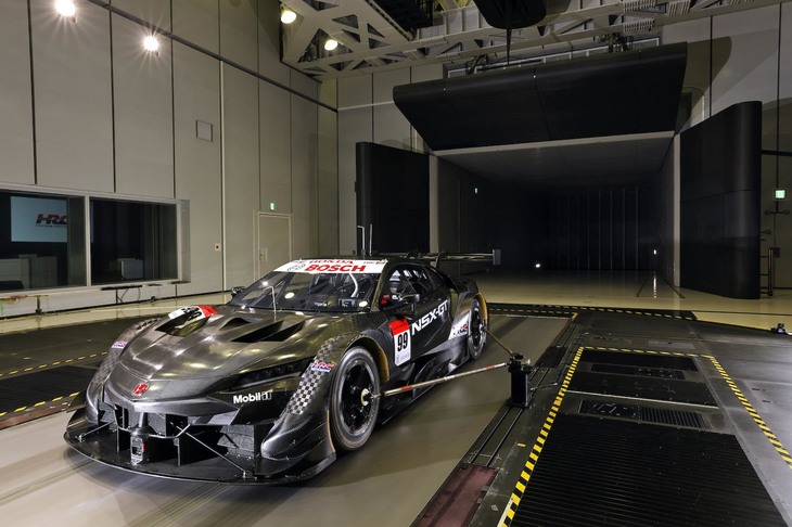 Sakuraの風洞は2種類ある。写真は車体前方に向けられた「ノズル」と呼ばれる送風口から風を吹き付ける「オープンジェット」形態のもので、再現できる最高速は200km/h。もうひとつは、周囲の壁や天井が車体の流線に合わせて変形し、測定誤差を減らすことができる「アダプティブ・ウォール」式で、こちらは最高288km/hまでのテストが可能という。車体下のムービングベルトは、車高の低いレーシングカーに適した「シングルベルト」。同じ栃木県にあるホンダの「ものづくりセンター」には、市販車がテストしやすいようにベルトを分けた「5ベルト」があり、適宜使い分けている。