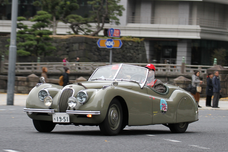 渋いカラーリングに、クルーのかぶる赤いキャップがアクセントになっている1954年「ジャガーXK120」。