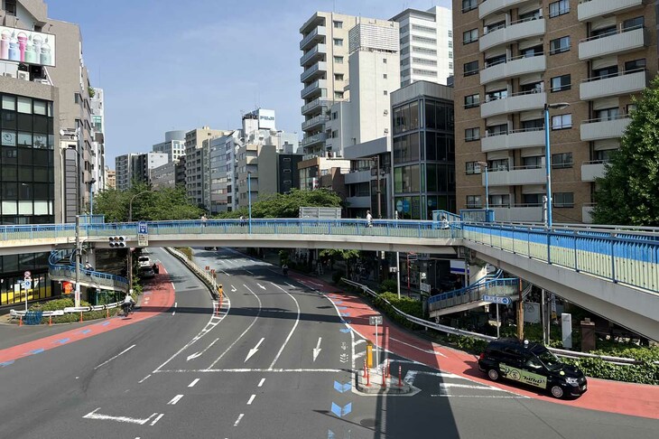 東京・渋谷の明治通りと駒沢通りの交差点に設けられたブルーの自転車ナビライン（写真中央）。左折専用レーン上（この場所は常時左折可）では、左折車両の右側を自転車が通るように案内されている。自転車ナビラインは、自転車の交差点における安全な通行を促すとともに、自転車利用者等に自転車の通行動線を知らせる青色矢羽根型法定外表示をいう。