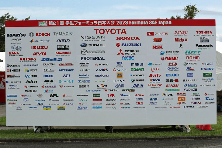 「学生フォーミュラ日本大会2023」の協賛企業。未来の日本自動車産業を支える金のタマゴ（！）が集まるイベントだけに、協賛企業は国内の自動車および二輪車メーカー全社をはじめ、有力サプライヤーや商社など、今回も計200社を超える見込み。ICVクラスに使われるエンジン（実質的には二輪用）と、各種部品やコンポーネンツの多く、そして審査員などは協賛各社から提供・派遣される。