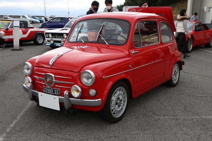 「フィアット・アバルト850TCベルリーナ」（1963年）。「フィアット600」をベースとしたモデルで、排気量を633ccから847ccまで拡大。エンジン内部にも鍛造クランクシャフトをはじめとした強化パーツが採用された。圧縮比も高められており、最高出力は52HP、最高速度は140km/hを記録した。このため、足まわりやブレーキもその動力性能に見合うものにアップデートされている。アバルトのツーリングカーではおなじみの、エンジンフードを持ち上げて固定できる構造も、このモデルから採用された。