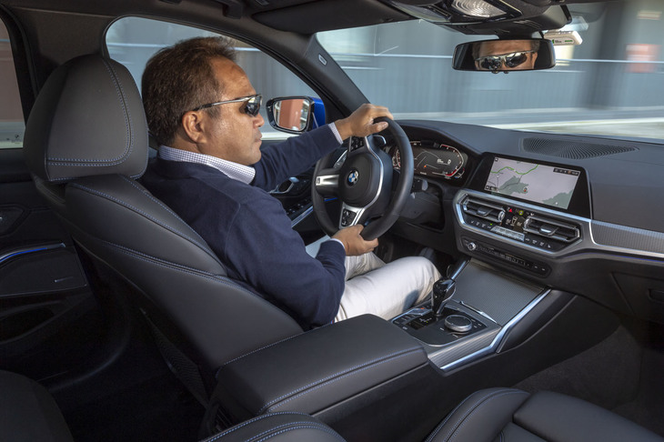 「330i Mスポーツ」のステアリングを握る筆者。コックピットは高めのセンターコンソールで包み込まれるような雰囲気が演出されている。