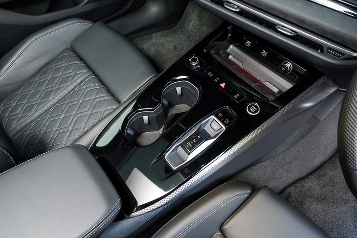 全体がピアノブラック仕上げのセンターコンソールはくぼみこそあるものの、飛び出すものがひとつもないフラットデザイン。消しゴムのようなサイズ感のシフトセレクターは指一本でも操作できる。