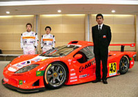 間もなくシェイクダウンを迎えるという新しいGT300マシン「ガライヤ」を囲む、鈴木亜久里総監督（右手前）とドライバーの新田守男（左）、高木真一（右）。アペックスの協力により生まれたこのレーシングカーは、全長×全幅×全高＝4544×1924×1147mmのボディに、300ps以上を発生するという日産製の2リッターエンジン、6段シーケンシャルギアボックスを搭載する