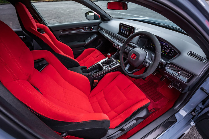 赤い専用スポーツシートやアルカンターラ巻きのステアリングホイールが目を引くインテリア。フロアマットもホンダアクセスの純正アクセサリーで、真っ赤なカーペットにマッチする色合いの開発に苦労したという。