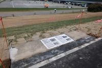 切り出された約3.3m幅の観客席の座面部分が、新旧2枚並べられた記念プレートの額縁のように埋め込まれている。