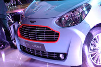 グリルに（樹脂ではなく）アルミを用いるなど、デザインだけでなく素材選びにもこだわったという。展示車のグリルに見られるオレンジ色の縁取りは、アストン・マーティンのレーシングカーに見られる意匠である。