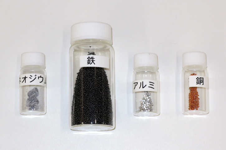 磁石の素材。磁石に使用する元素のうち約3割がレアアースであり、その大部分をネオジムが占めているというが、今後はそれを比較的入手しやすいランタン（La）やセリウム（Ce）に置換し、ネオジムの割合を削減していく。