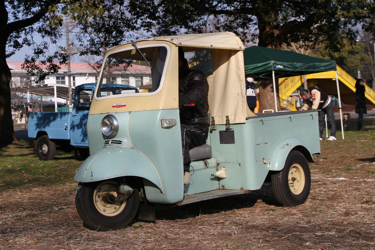 1960年「ダイハツ・ミゼットDKA」。前年に2灯式で丸ハンドル仕様の「ミゼットMP2」も発売されていたが、廉価版として併売されていたバーハンドル仕様の“ひとつ目小僧”。249cc空冷2ストローク単気筒エンジンで後輪を駆動する。