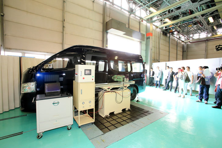 ドア開閉耐久試験の様子。車両脇の機械がスライドドアの開閉を延々と繰り返すことで車体に負荷を与え、ドアの開閉に対する耐久性が検証される。